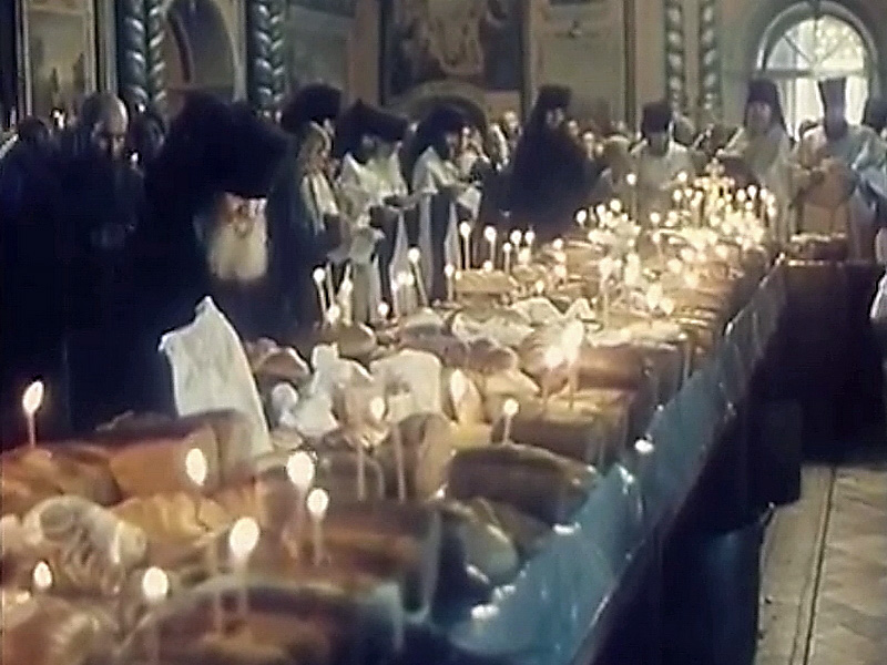 Отец Софроний, слева от стола с приношениями, по своему обыкновению следит за свечками на соборной панихиде